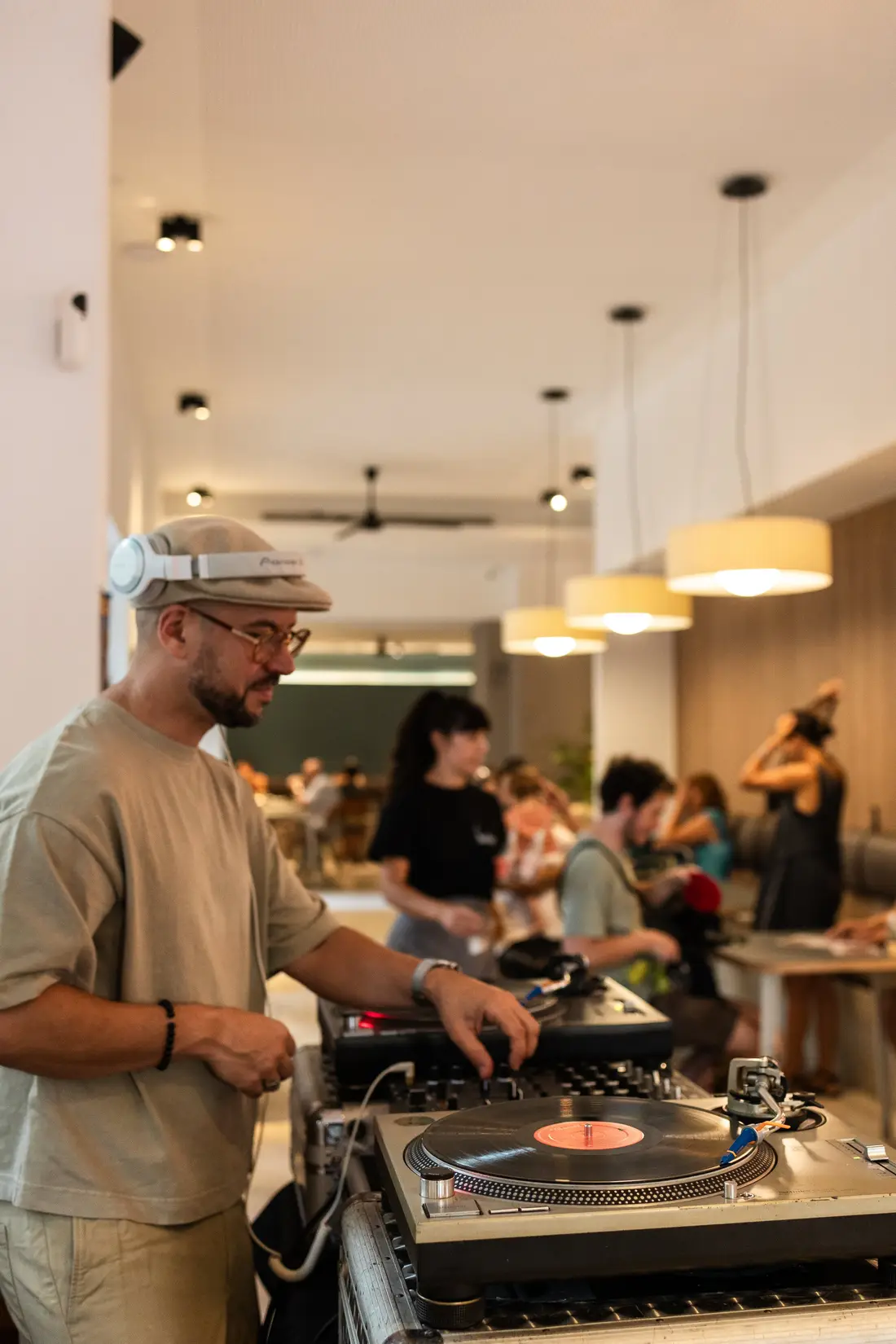 Un DJ pinchando vinilos dentro de un Federal Café